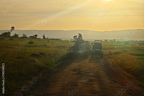 An SUV car for safari on the road in the African savannah. Tourists watch the animals in the car. game drive in early morning at dawn.