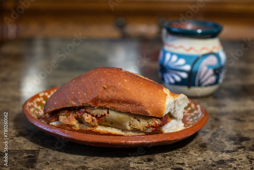 front view of tamale cake in red sauce on clay plate. Mexican food. torta