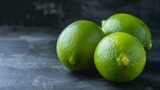 Close-up of fresh green whole limes with vibrant citrus texture on a dark background