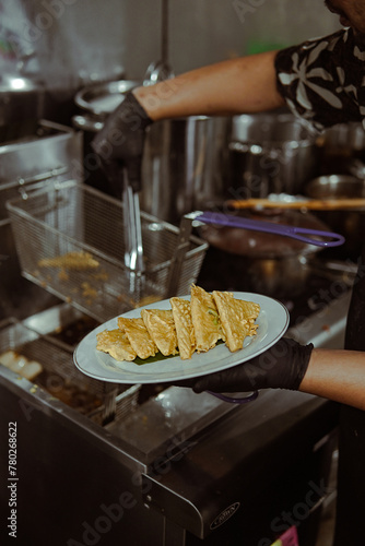 Tempe Mendoan Person Holding Plate of Food in Kitchen