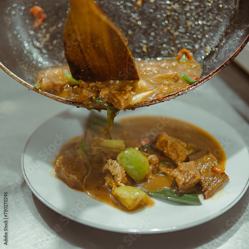 Making oseng mercon Plate of Food With Wooden Spoon in It photo