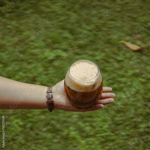 Person Holding Glass of Beer in Hand at Party Celebration