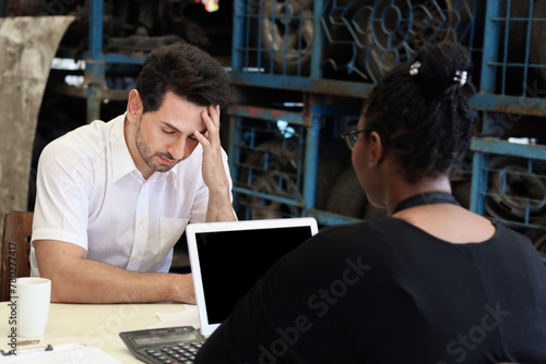 Unhappy man feels confused by employee description the prices of services and products in auto spare parts store warehouse with secondhand engine parts. Disappointed buyer disagrees with price.