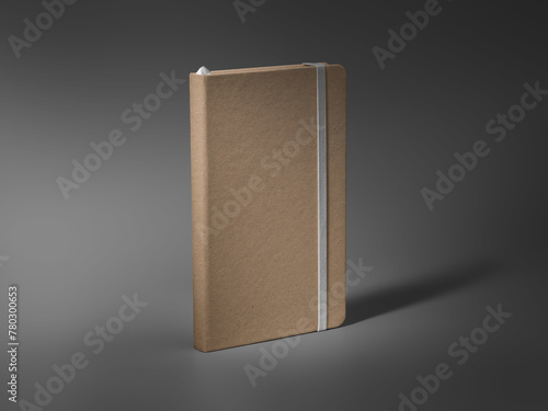 Mockup of a closed craft notebook, standing on a darkened background, with a white elastic band, a bookmark.