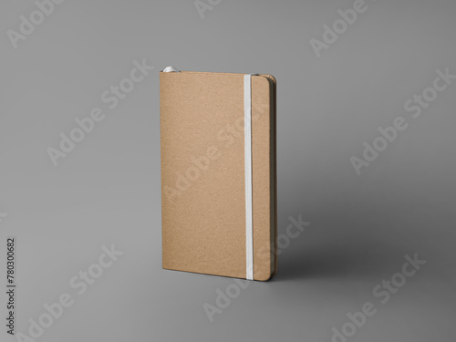 Mockup of closed craft notebook, standing on background with shadows, with white elastic band, bookmark, textured hard cover.