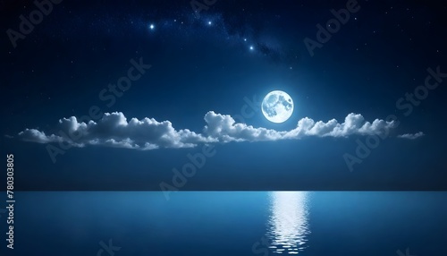 The full moon is shining brightly in the night sky, casting its reflection on the calm surface of the body of water below photo