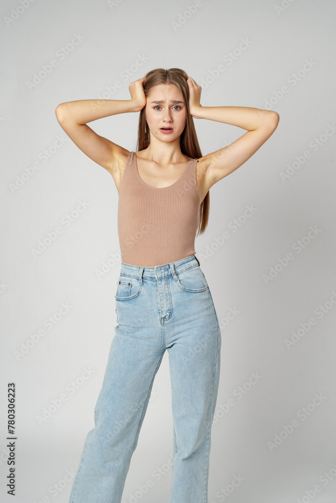 Young woman is in shock or surprise of the news against gray background Young woman is in shock or surprise of the news against gray background