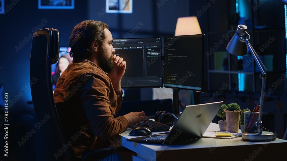 Developer typing code in home office, using Java programming language to develop software application. It professional using multimonitor PC setup and laptop to finish tasks, camera A Developer typing code in home office, using Java programming language to develop software application. It professional using multimonitor PC setup and laptop to finish tasks, camera A