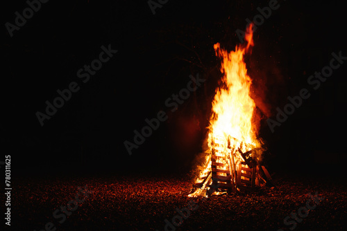 Bonfire burning at night, bright orange flames of fire, selective focus