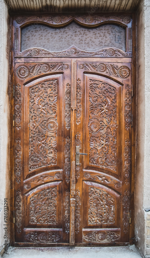 An ancient wooden door with patterns and ornaments in the ancient city of Khiva in Uzbekistan, wood carving