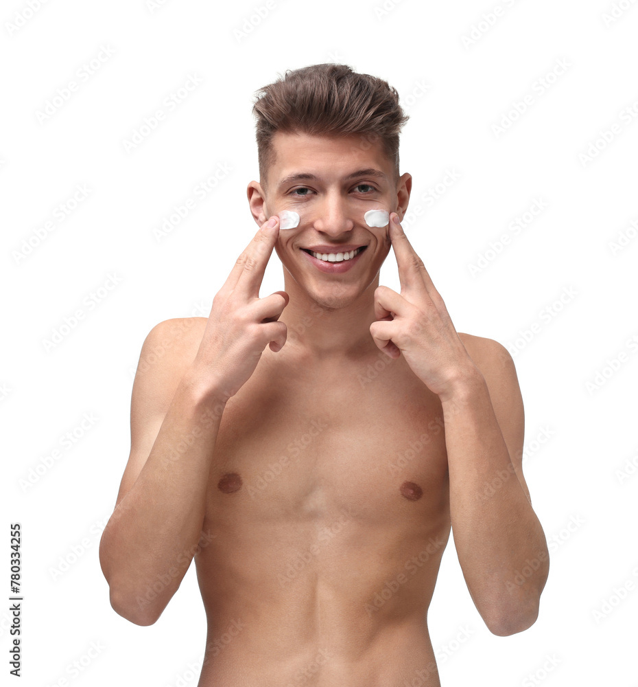 Fototapeta premium Handsome man applying moisturizing cream onto his face on white background
