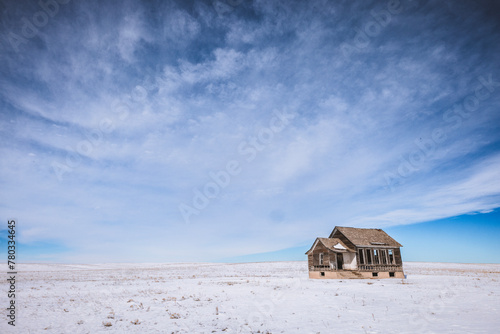 Abandoned run down house in winter in the middle of Nebraska prairie photo