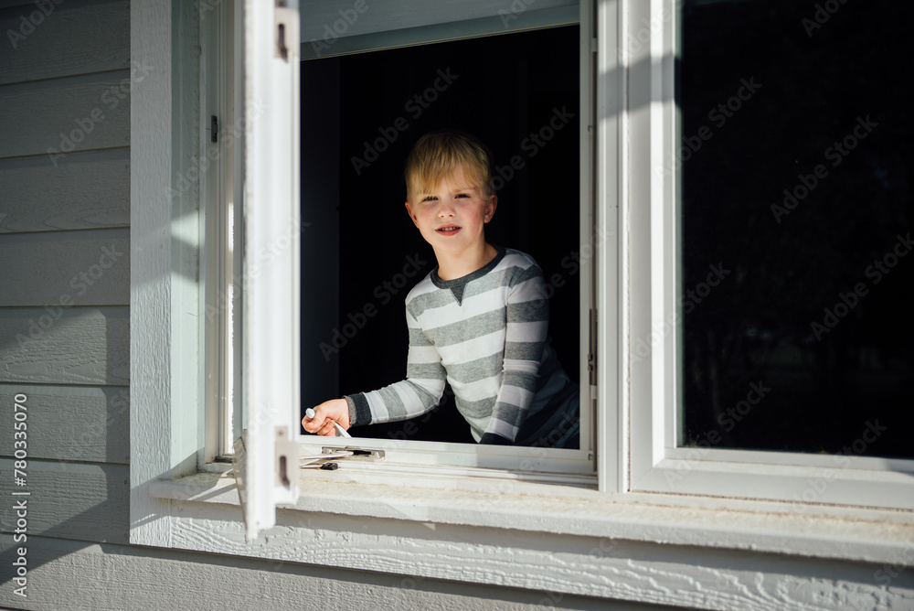 Portrait of young boy opening window while looking outside Portrait of young boy opening window while looking outside