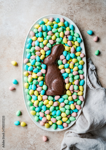 Overhead of chocolate bunny in tray of mini chocolate Easter eggs. photo