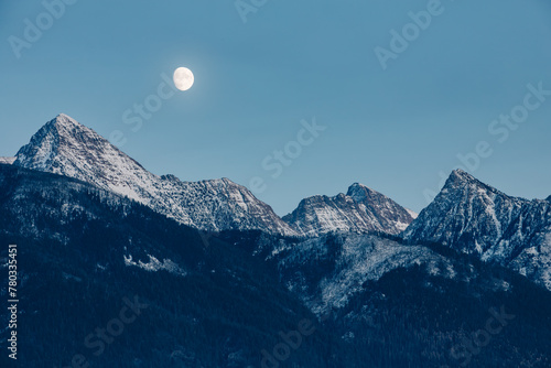 Mission Mountain peaks and moon during blue hour photo