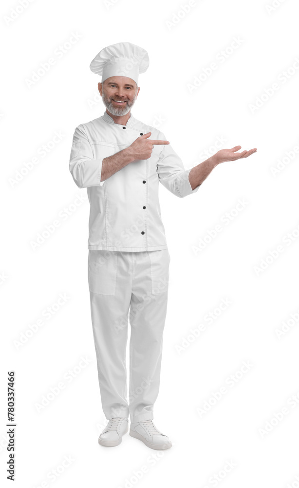 Happy chef in uniform pointing at something on white background
