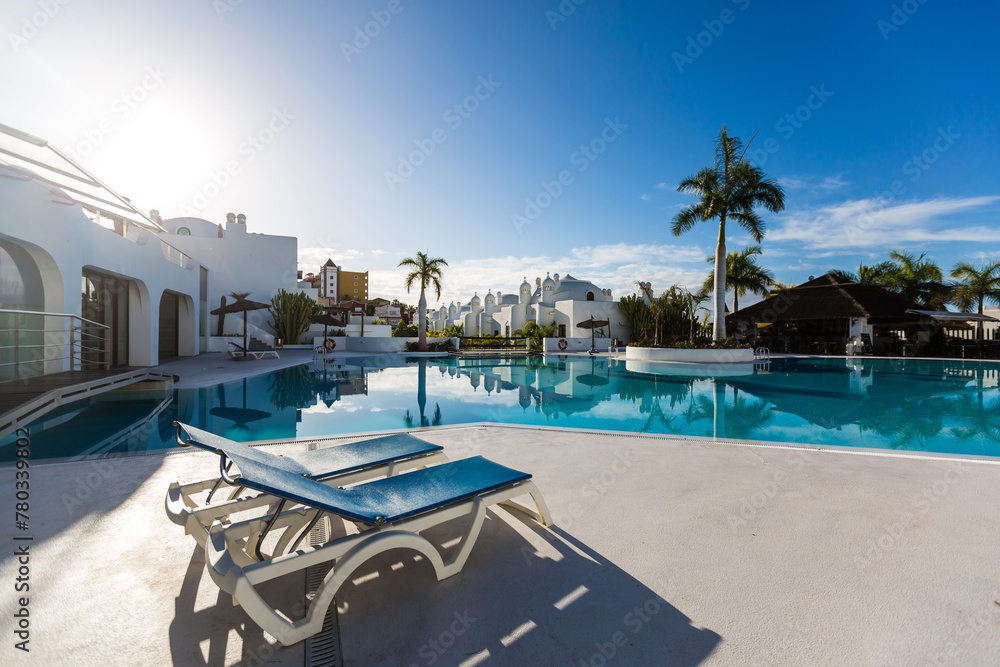 swimming pool with empty sun loungers swimming pool with empty sun loungers