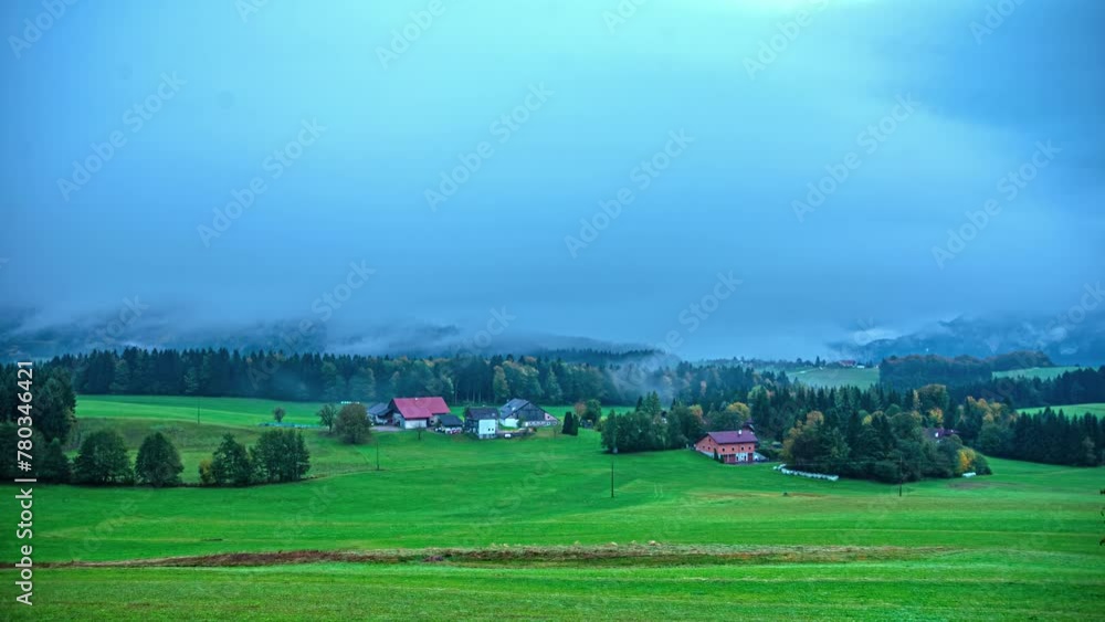 Small village in Alps with thick fog flowing above, time lapse view Small village in Alps with thick fog flowing above, time lapse view