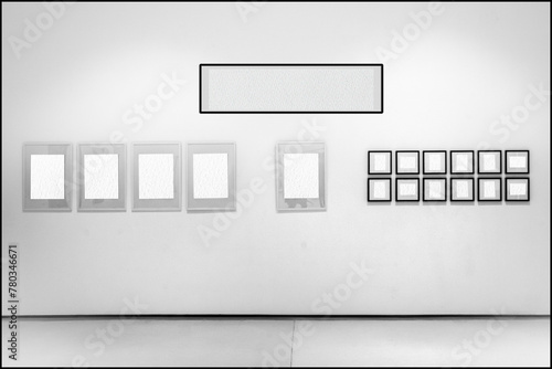 In sala di esposizione dalle pareti bianche sono esposte cornici con l'interno vuoto. L'interno bianco delle cornici permette l'inserimento di immagini o testo. Serie di cornici allineate. photo