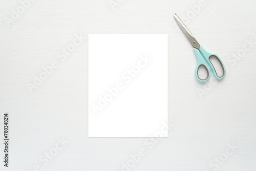 Blank US letter size paper sheet mockup for paper crafts, worksheet, activity sheet, coloring page, flyer design, flat lay composition with scissors on white wooden table.