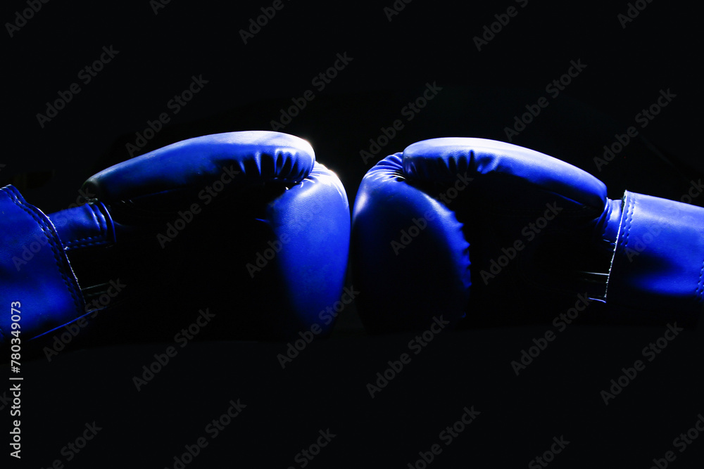 Close up blue boxing gloves with darkness background.