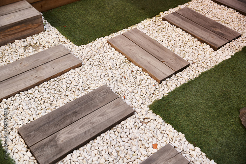 Photography A serene garden space featuring wooden steps leading down to a gravel pathway su