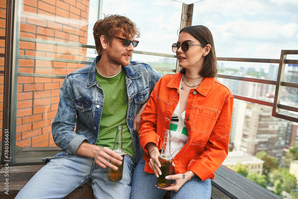 A man and a woman sitting on a ledge, peacefully contemplating the vast scenery below them A man and a woman sitting on a ledge, peacefully contemplating the vast scenery below them