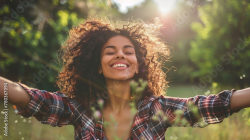 Portrait of a free happy latin american woman with open arms enjoying life in meadows and nature background , young joyful latina female with good mental health photo