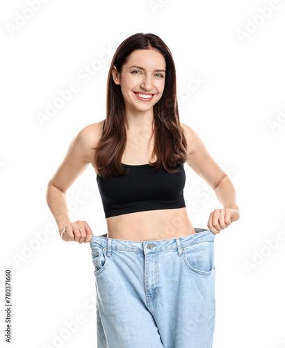 Happy young woman in big jeans showing her slim body on white background © New Africa