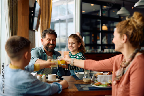 Happy family having fun and toasting during breakfast in  hotel restaurant. photo