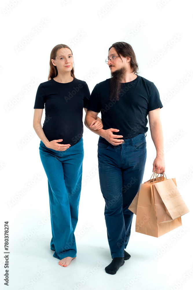 Portrait happy young pregnant woman and her husband with shopping bags and touching her big belly isolated on white background. Pregnancy shopping concept happy young family with shopping bags