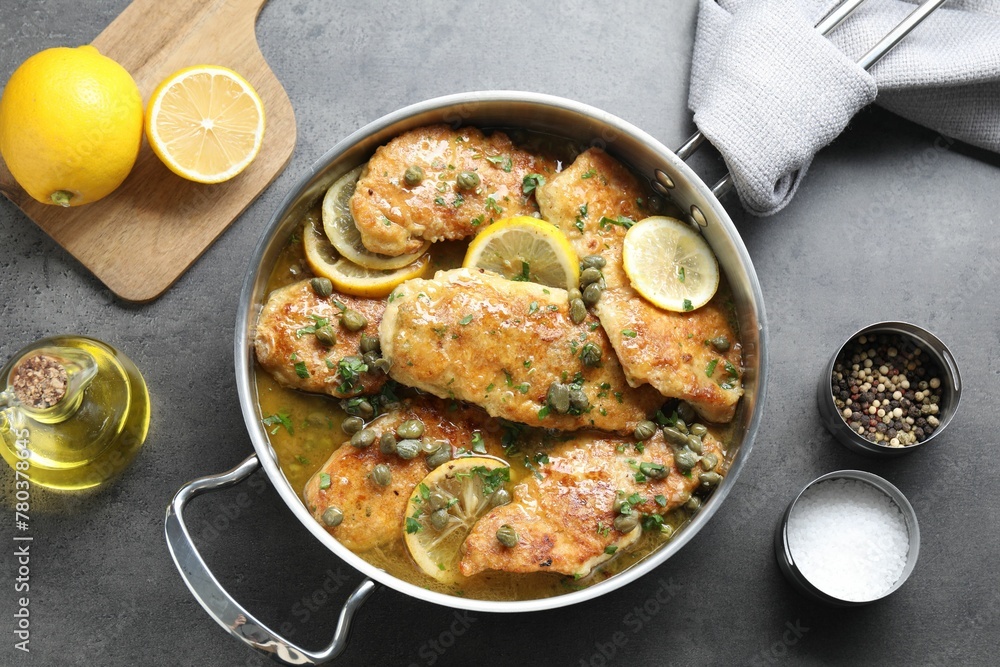 Delicious chicken piccata on grey table, flat lay