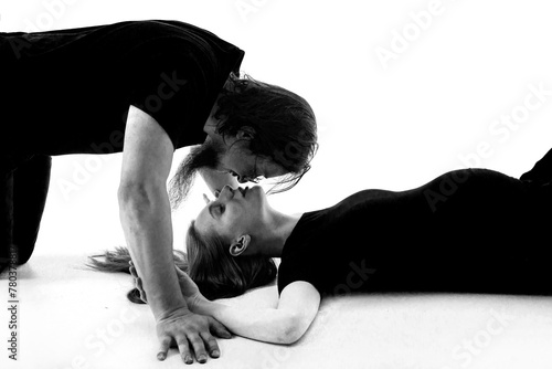 Obraz na płótnie Beautiful pregnant woman and her handsome husband are kissing while spending time together isolated over white background wall. beautiful young couple expecting baby standing together and touching w salonie