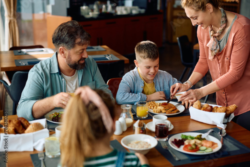 Happy boy enjoying with his family in breakfast time at hotel.