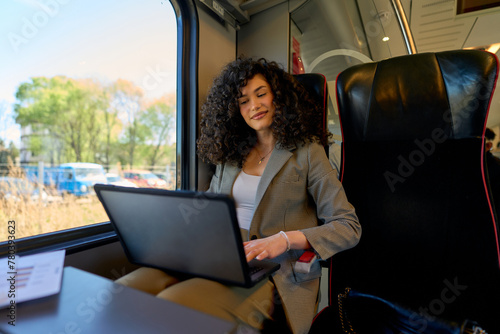 Combining business with the beauty of travel, a young entrepreneur manages her tasks on-the-go, with a scenic backdrop blurring by her train window.