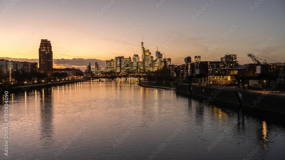 Cityscape with modern buildings reflected in water at sunset