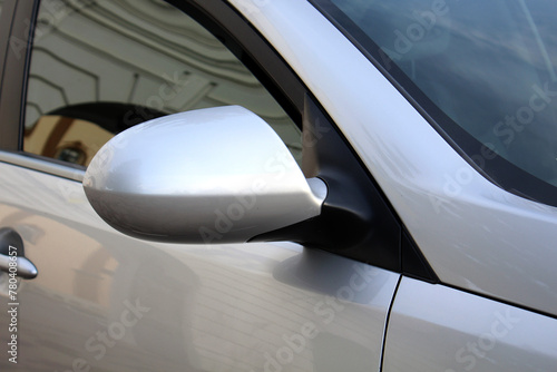 Close-up of the grey side mirror of the car. Car mirror with blind spot warning. Car Mirror Cover Rearview Mirror.
