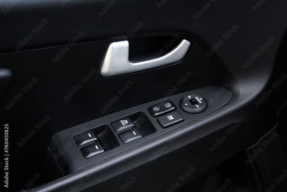 Window control buttons in modern SUV. Car leather interior details of door handle with windows controls and adjustments. Modern SUV interior.