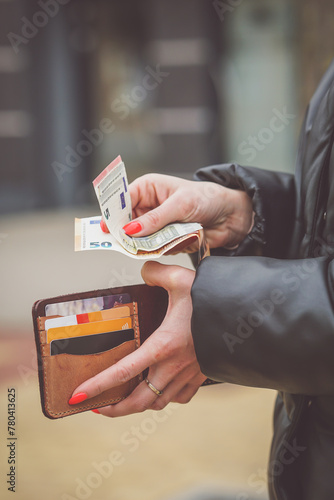 Woman hands taking money out of  leather wallet