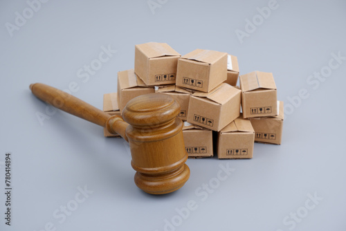 Tariffs and taxes concept. Judge gavel and many carton boxes on gray background.	