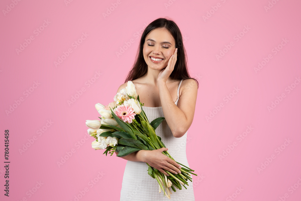 Beautiful lady with bouquet on pink background