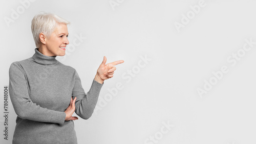 Senior lady gesturing to the side with a smile photo