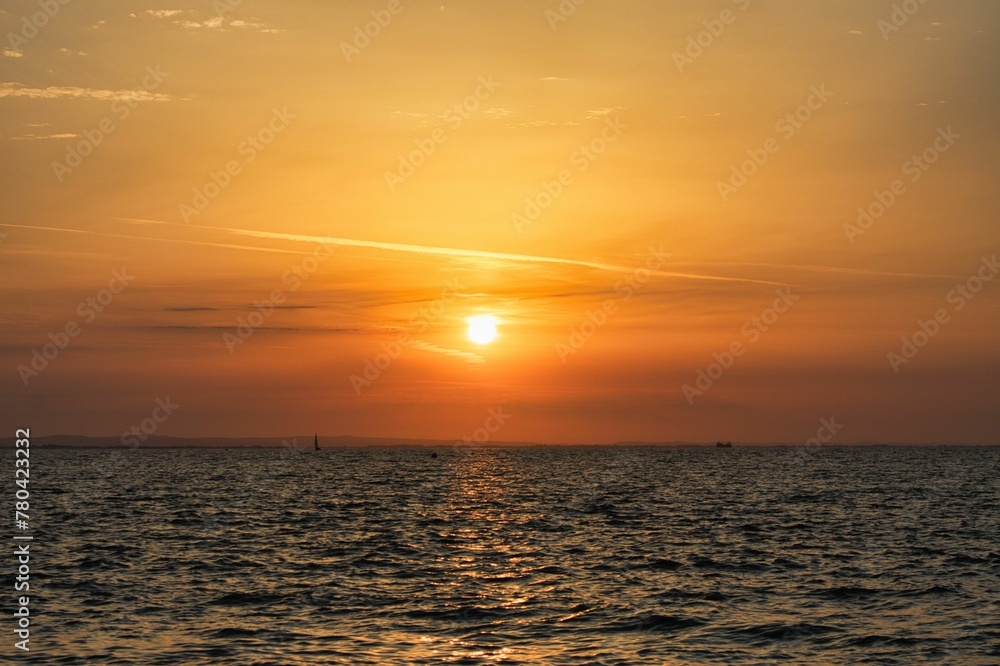 Scenic shot of a golden sunset and its reflection on the surface of a calm sea