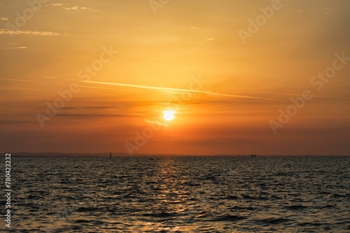 Scenic shot of a golden sunset and its reflection on the surface of a calm sea