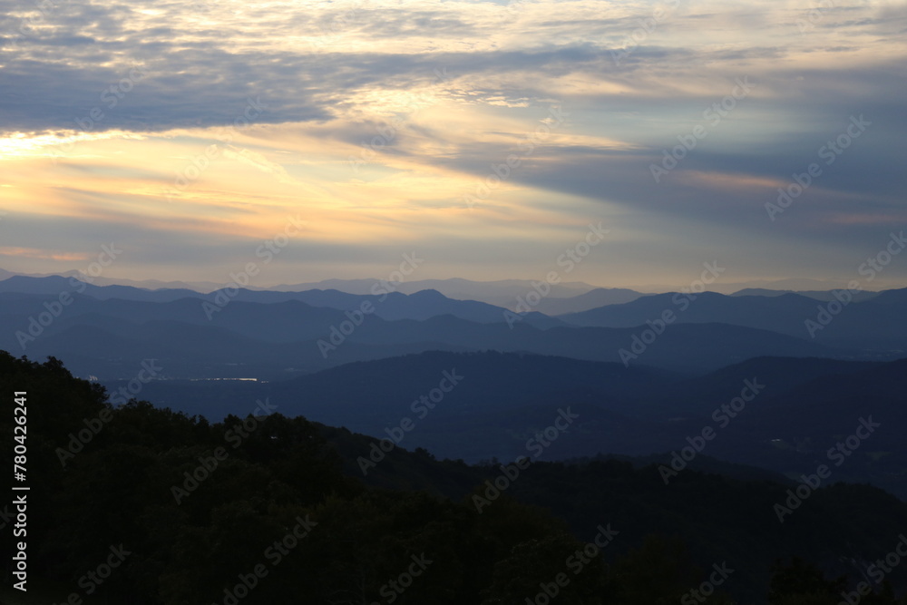 Aerial view of a beautiful forest near the mountains at sunset