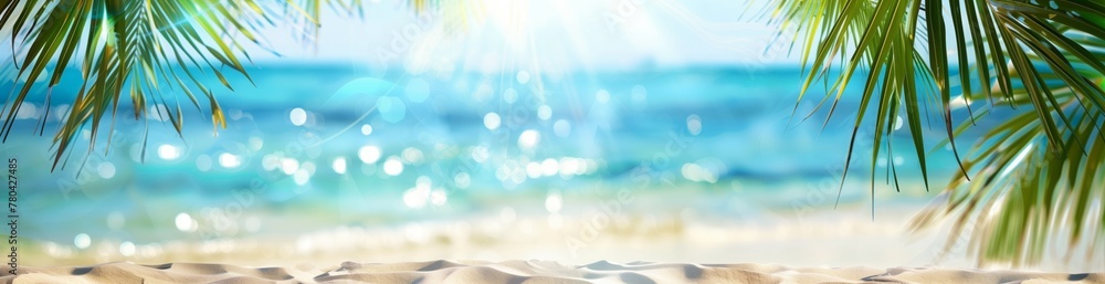 Beautiful summer background with palm leaves against the backdrop of a sandy sea beach under a blue sky. The background is blurred. Copy space. Banner. - obrazy, fototapety, plakaty 