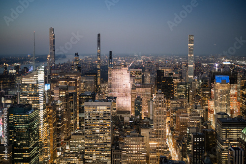 Aerial view of illuminated tall modern skyscrapers in city at dusk photo