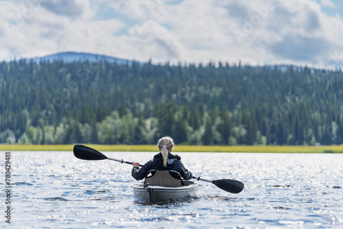 Senior woman kayaking in lake on sunny day
