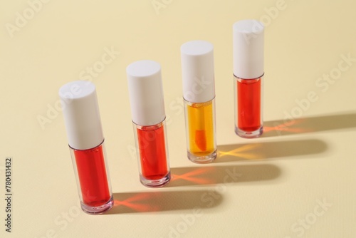 Many bright lip glosses on beige background