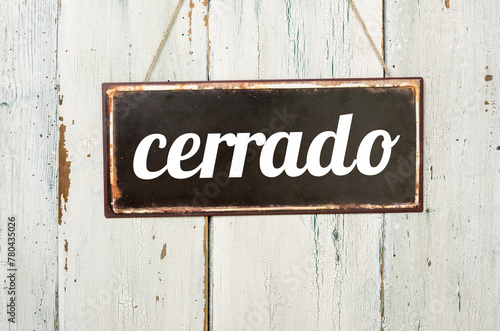Vintage tin sign on a wooden background - Closed in spanish